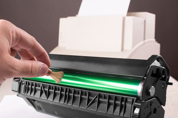 Technician hand cleaning printer toner cartridge - How To Clean A Printer Drum